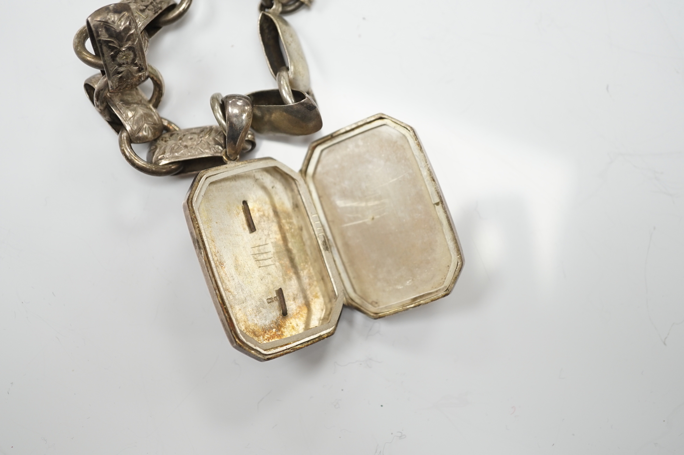 A Victorian silver octagonal locket, Chester, 1880, 44mm, on an engraved white metal chain.